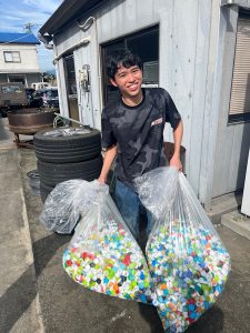 集めたペットボトルキャップを運ぶスタッフ